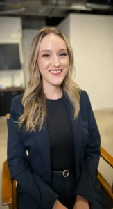 Smiling woman in a navy suit with professional corporate makeup, styled by Waring Makeup, Ottawa Office Makeup Services.