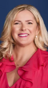 Smiling woman in a red outfit with polished corporate event makeup, styled by Waring Makeup, Ottawa Corporate Makeup Artist.