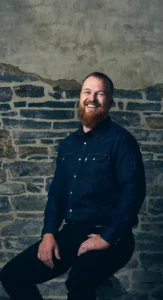 Smiling man in business casual attire with a groomed and polished look, styled by Waring Makeup, Ottawa Office Makeup Services.