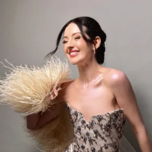 Joyful bride in beaded gown with classic makeup by Waring Makeup, Ottawa Wedding Makeup Artist, holding feather accents.