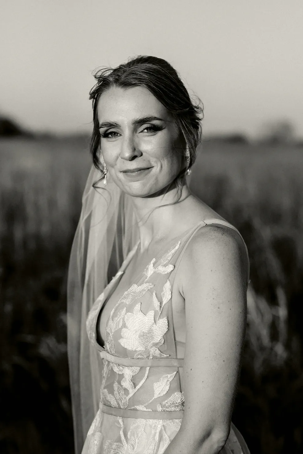 Woman with bridal makeup in wedding dress standing in a field